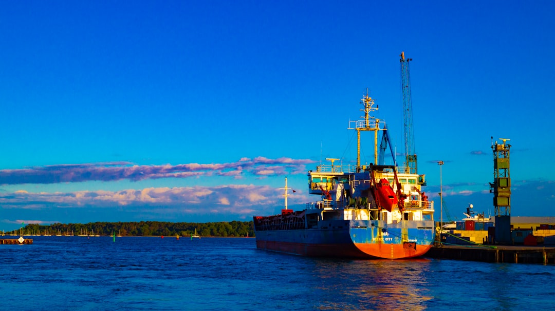 Poole, Dorset: blue and red ship on sea under blue sky during daytime
